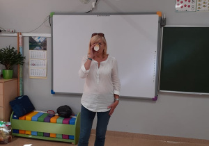 Nauczycielka klasy trzeciej pijąca sok z ctryny po którym musi się uśmiechnąć.