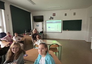 Uczniowie siedzą w ławkach podczas zebrania.