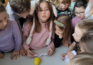 Dzieci nad kolejnym zadaniem, które trzyma jedna z dziewczynek.