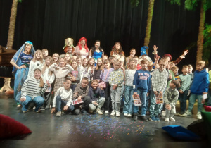 Klasa 4b na scenie teatru pozująca do zdjęcia z aktorami.