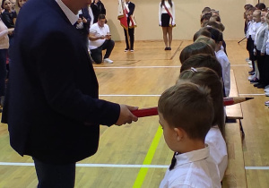 Pan dyrektor pasujący dużym ołówkiem dzieci na uczniów naszej szkoły.