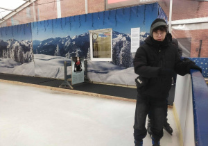 Uczeń klasy siódmej w łyżwach wchodzący na taflę lodowiska.