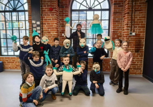 Klasa 3b pozująca do wspólnego zdjęcia. Część dzieci ma założone maski, inne pozują z lalkami.