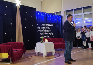 Dyrektor składający życzenia świąteczne w tle dekoracja na Jasełka