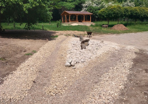 Fragment ogrodu zwany ogrodem deszczowym - uporządkowanym teren obsypany żwirem ogrodowym przygotowany do obsadzenia roślinami.