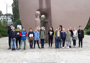 Grupa dzieci przed Pomnikiem Pękniętego Serca