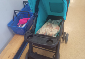 Wózek dziecięcy, a w nim torb z przyborami szkolnymi.