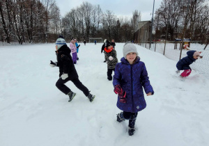 Biegające dzieci w zimowej aurze.