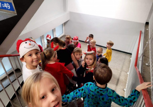Dzieci z klasy 1b na schodach prowadzących do szatni, w poszukiwaniu niespodzianki od Mikołaja.