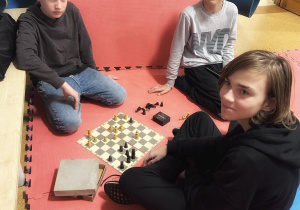 Trzej chłopcy grający w szachy.