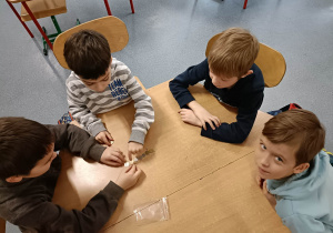 Chłopcy układający monety o różnych nominałach.