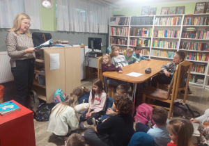 Wychowawczyni klasy 3a czytająca dzieciom książkę w bibliotece szkolnej.
