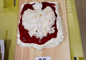 Ciasto bezowe w kształcie godła z białym orłem na czerwonym tle.