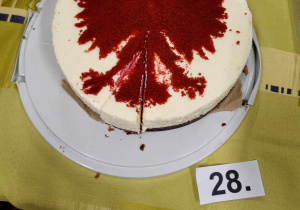 Konkursowe ciasto z białym wierzchem, na którym widnieje czerwony orzeł.