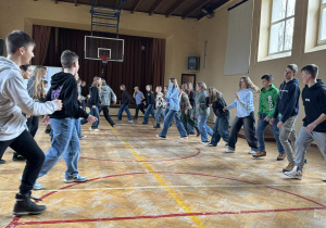 Uczniowie na sali gimnastycznej uczą sie tańca irlandzkiego