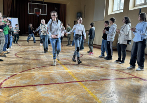 Uczniowie na sali gimnastycznej ucza sie tańca irlandzkiego