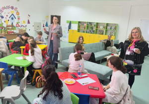 Uczniowie w sali siedzą przy stolikach i słuchają nauczycielki z Macedonii a p. Justyna w roli tłumacza