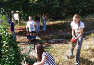 Uczniowie przy pracach porządkowych w szkolnym ogrodzie.