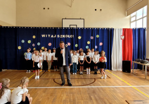 Dyrektor przemawiający do zgromadzonych i składający życzenia.