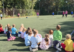 Uczniowie kilku klas zgromadzeni na boisku szkolnym podczas