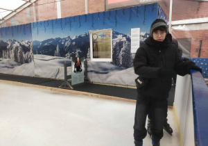 Uczeń klasy siódmej w łyżwach wchodzący na taflę lodowiska.