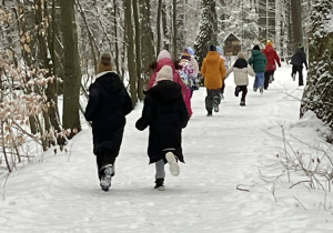 Dzieci biegnące leśną ścieżką.