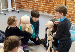 Grupa uczniów z lalkami teatralnymi w czasie warsztatów.