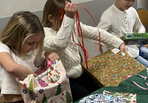 Dzieci otwierające prezenty.