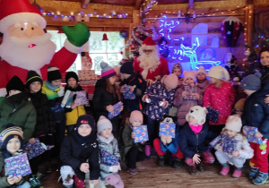 Uczniowie klasy 1a pozujący do zdjęcia z Mikołajem i wychowawczynią.