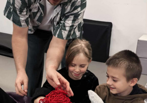 Uczniowie klasy trzeciej podczas warsztatów teatralnych ze skarpetami na dłoniach jako pacynkami.