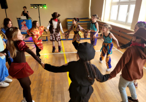 Dziewczynki z klasy trzeciej tworzące koło i wspólnie tańczące.