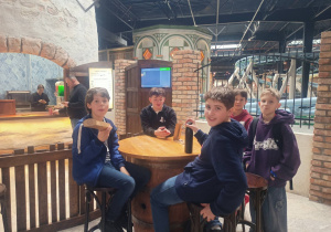 Pięciu chłopców podczas odpoczynku siedzących przy stoliku.