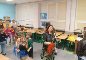 Dzieci podczas zabaw muzycznych z hula-hop i kolorowymi apaszkami.