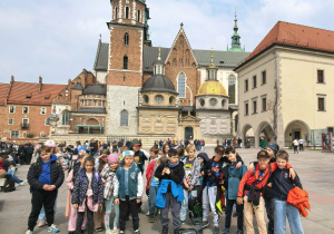 Uczestnicy wycieczki ustawieni do wspólnego zdjęcia, w tle katedra na Wawelu.