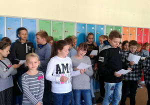 Zdjęcie pokazuje uczniów kilku klas z kartkami w ręku, śpiewających piosenkę "Panie Janie" w różnych językach.