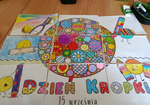 Plakat promujący Dzień Kropki podzielony na kilka części, pokolorowany przez uczniów.