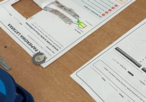 Leżące na ławce karty pracy "papierowa latarka".