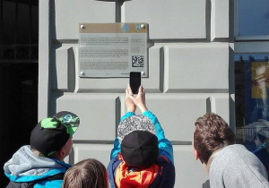 Uczniowie klasy Va czytający inofmację na jednym z budynków przy ulicy Piotrkowskiej.