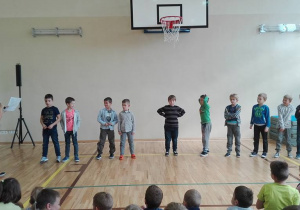 Chłopcy stojący na środku, odpowiadją na pytania w jednej z kokurencji.