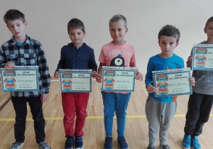Pięciu chłopców prezentujących swoje dyplomy superchłopaka.