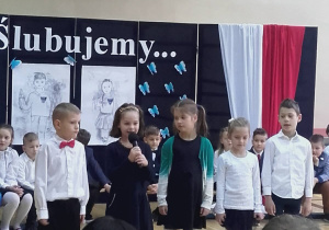 Na zdjęciu dzieci mówiace do mikrofonu jeden z wierszy.