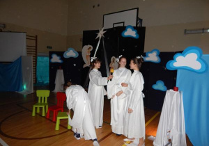 Dziewczęta z klasy VII w strojach aniołów odgrywają jedną ze scen.