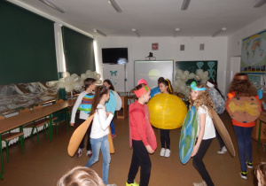 Uczniowie naszej szkoły przebrane za planety układu słonecznego, demonstrują przedszkolakom ruch planet wokół słońca.